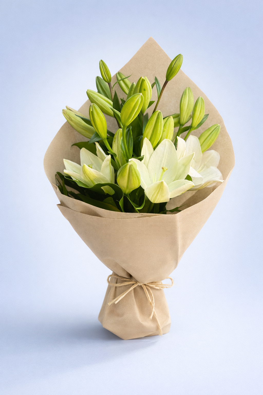 Bouquet of white and green flowers wrapped in brown paper on a light blue background